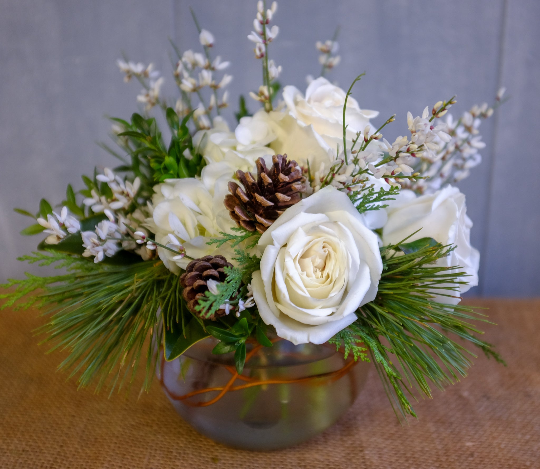 White winter flowers and evergreens and pinecones