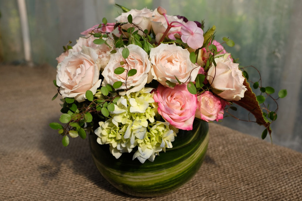 Low and lush flower arrangement with pink roses and creeping fig vine.  Michler's Florist
