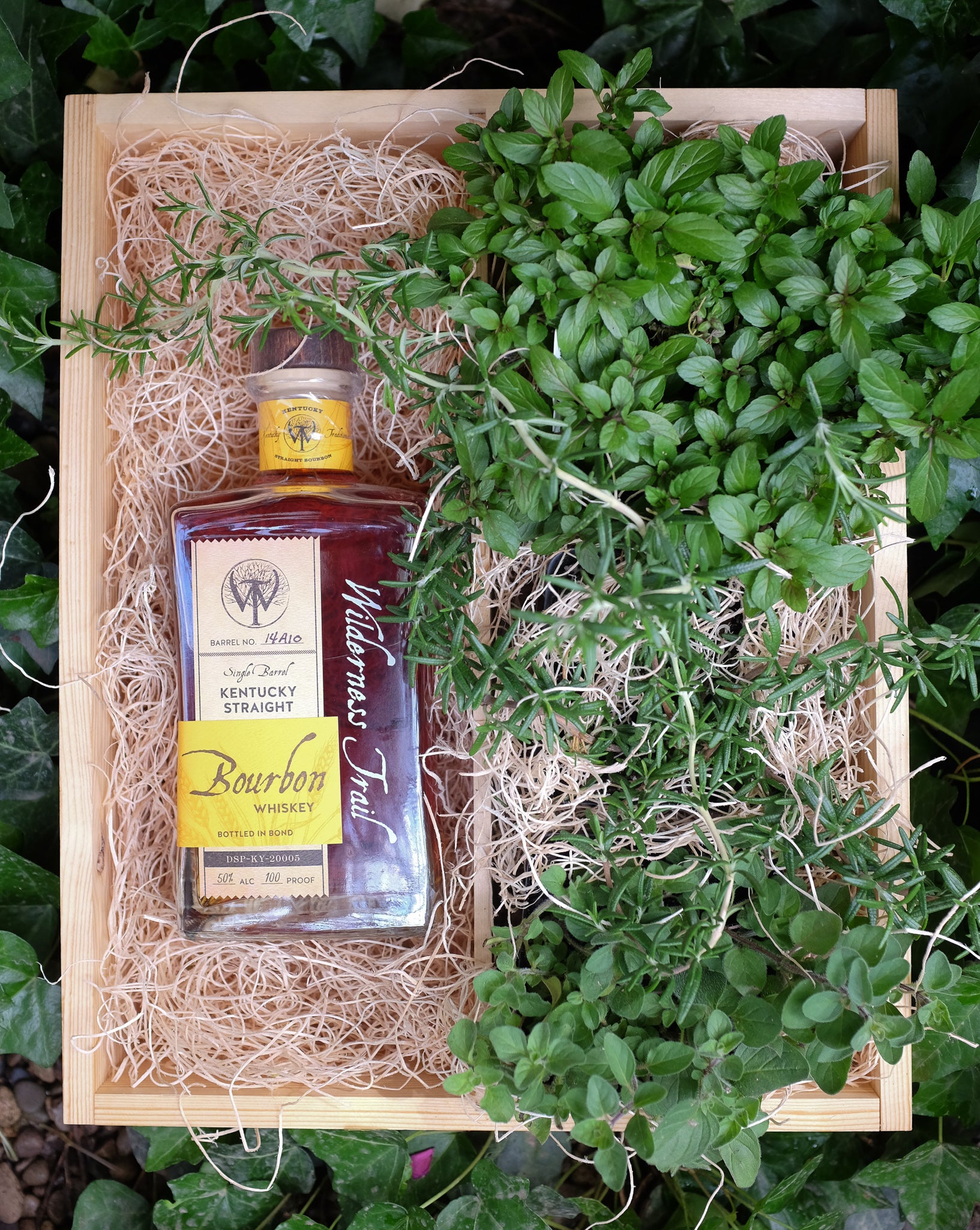 Wilderness Trail Bourbon Crate with rosemary and mint herb plants