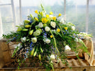 Casket Spray with Blue Delphinium, White Roses, Yellow Lilies and Yellow Freesia. Designed by Michler's Florist