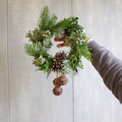 Miniature wreath with rustic jingle bells and pine cones.