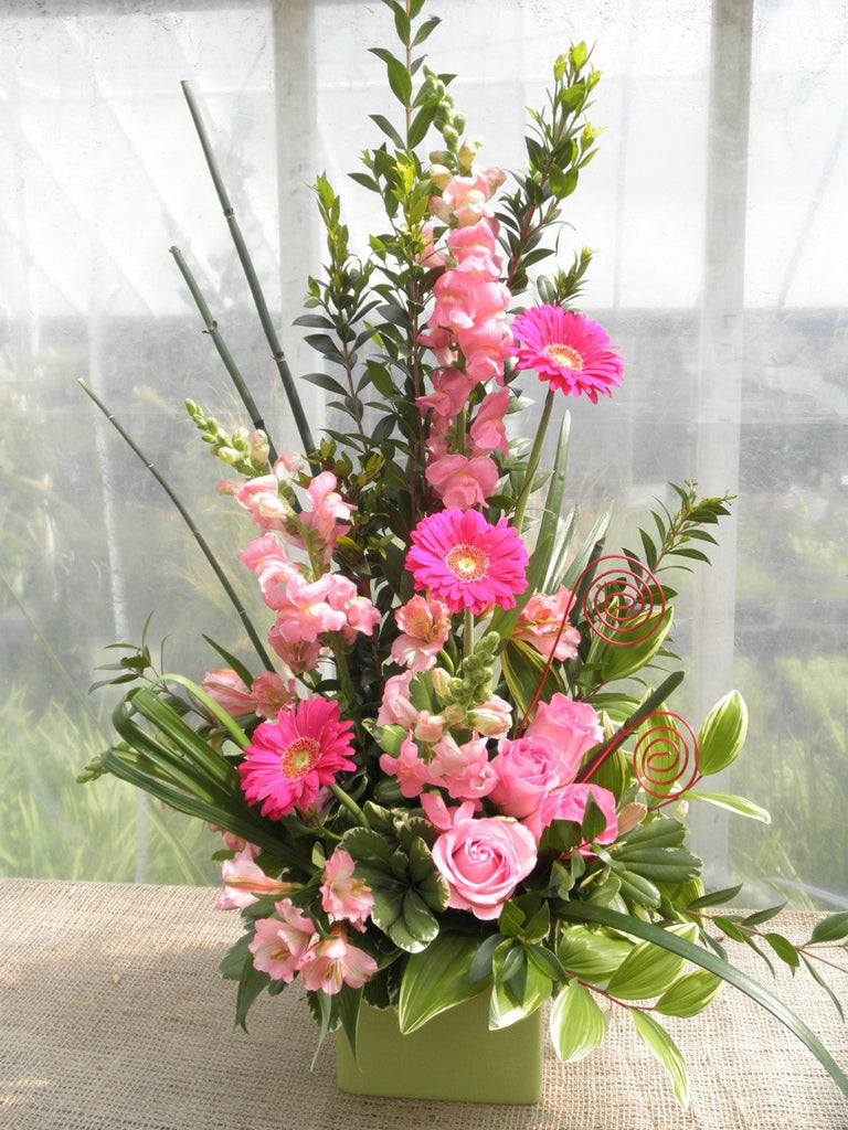 Pink floral arrangement by Michler's Florist with pink roses, gerbera daisies ,and delphinium 