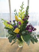 Floral Arrangement by Michler's Florist with yellow roses, tulips, delphinium, eucalyptus