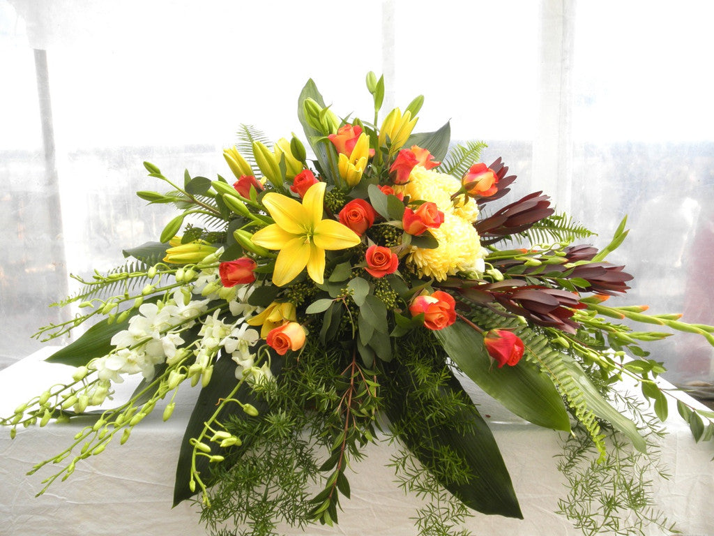 Casket Spray with Yellow Lilies, White Orchids, and Orange Roses.  Designed by Michler's Florist, Greenhouses & Garden Design