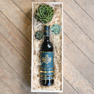 Narrow wooden crate with a bottle of wine and succulents.